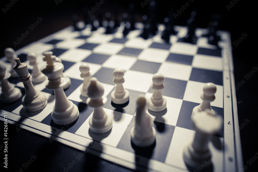 White and black pieces on chess board White and black pieces on chess board
