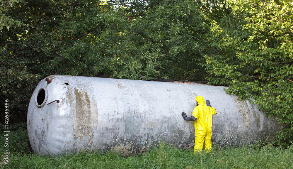 technician in uniform examining large stainless tank technician in uniform examining large stainless tank