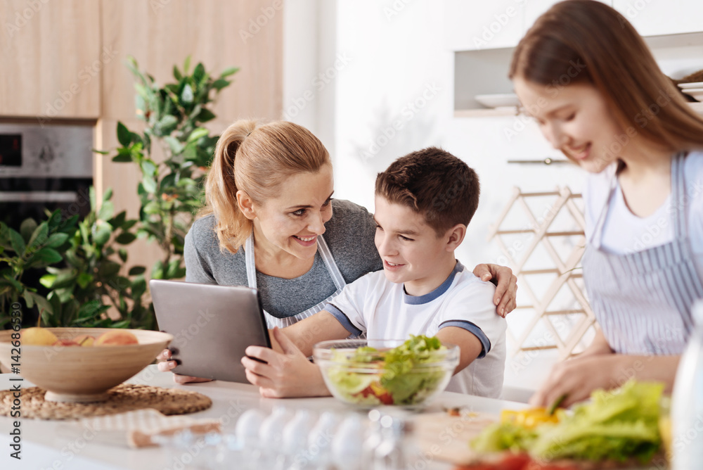 Positive boy spending time with his family in the kitchen