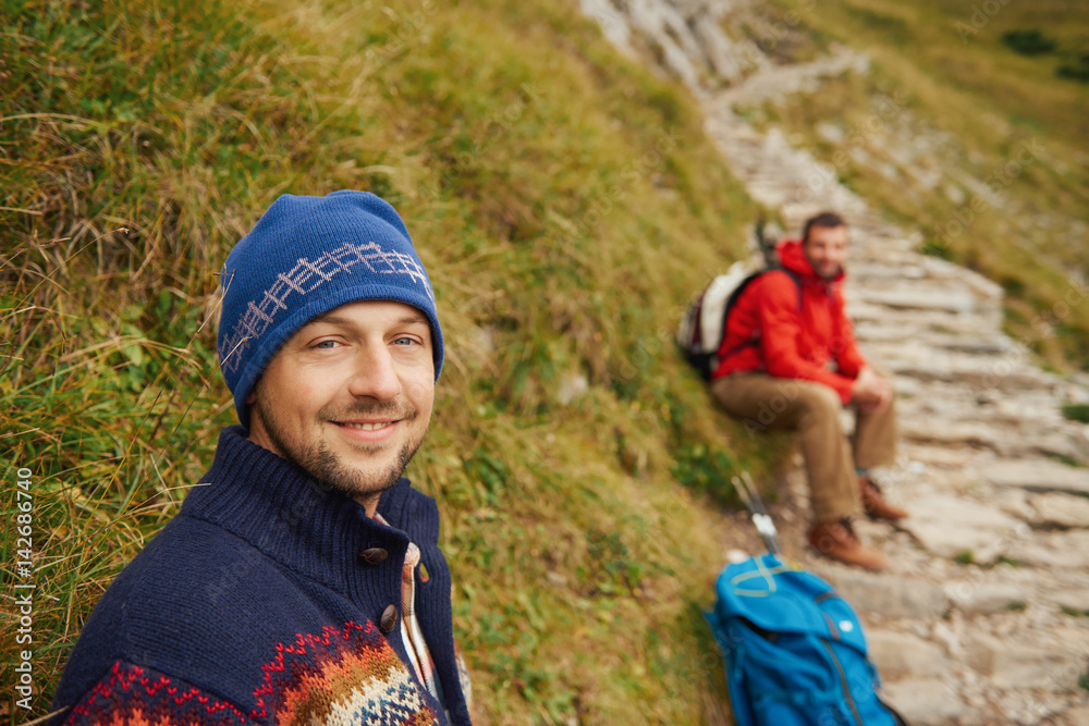 Smiling hikers resting on a rugged mountain trail