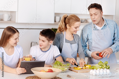 Cheerful loving family cooking dinner together