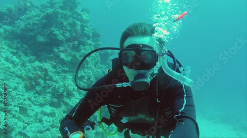 Diver diving takes selfie underwater. The hand shows the sign all okay