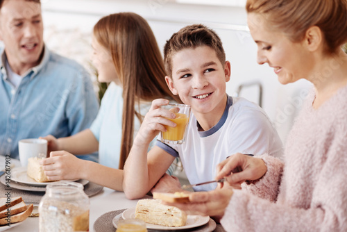 Cheerful boy having breakfast with his family