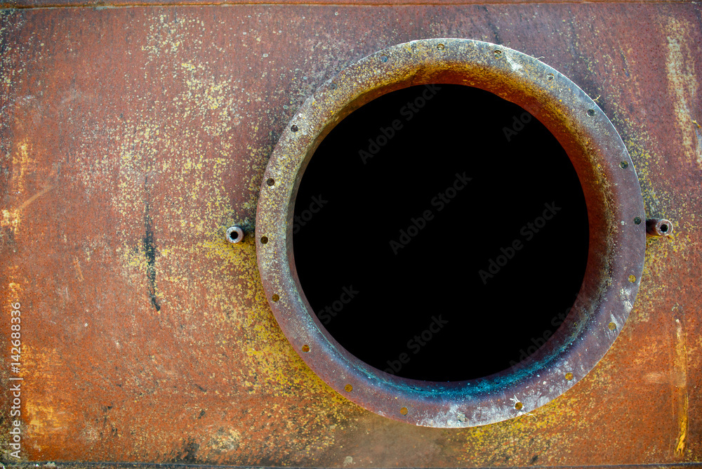 opened rusty manhole on orange fuel tank