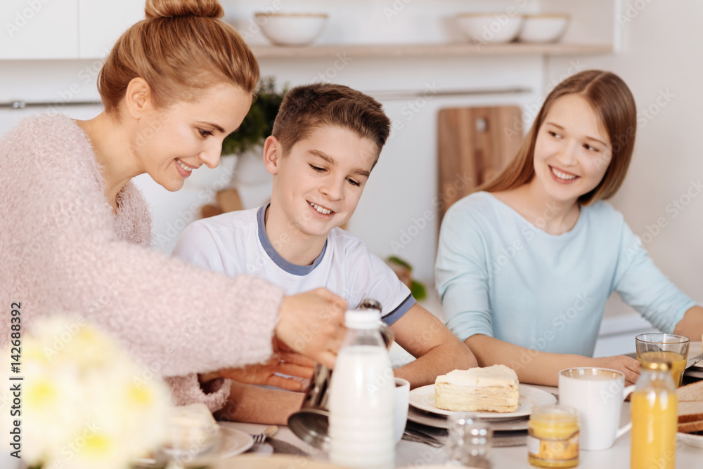 Positive mother having breakfast with her children Positive mother having breakfast with her children