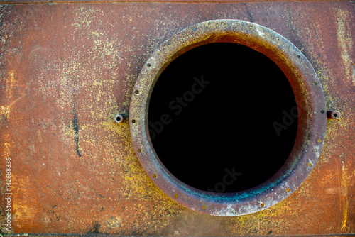 opened rusty manhole on orange fuel tank