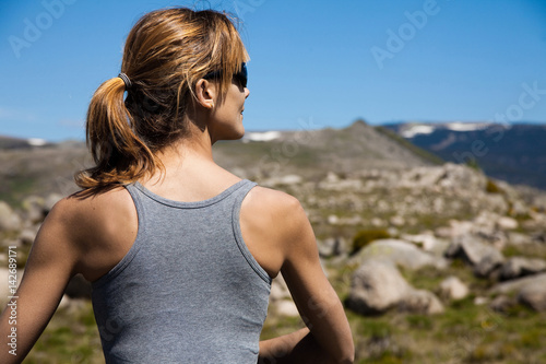 femme de dos assise dans les montagnes