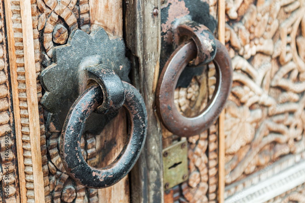 Old handles on the door with carved patterns and ornaments Old handles on the door with carved patterns and ornaments