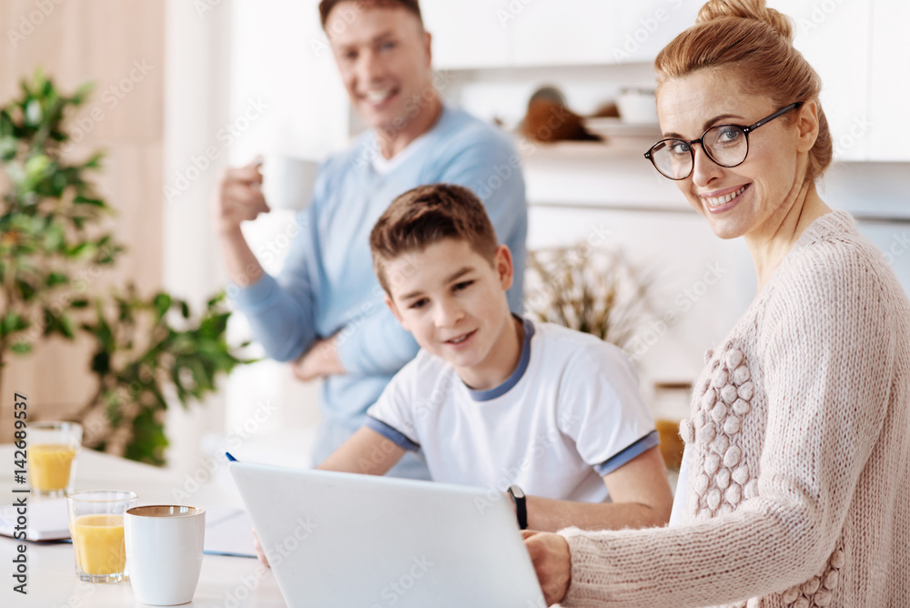 Cheerful mother helping her son with homework Cheerful mother helping her son with homework