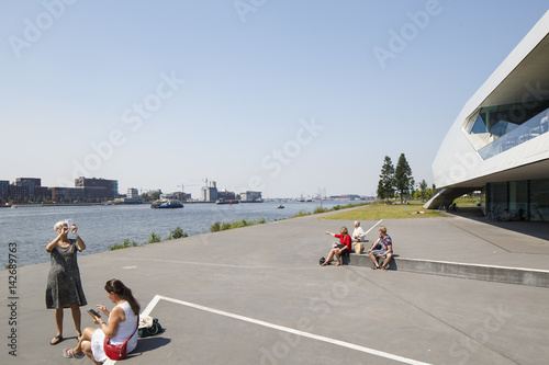 People enjoying the waterfront view at the water of the IJ in Amsterdam. photo