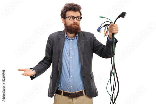 Confused guy looking at different types of electronic cables