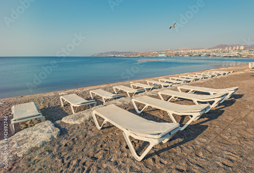 Sandy beach with deckchair waiting for tourists in Eilat -famous resort in Israel and Middle East