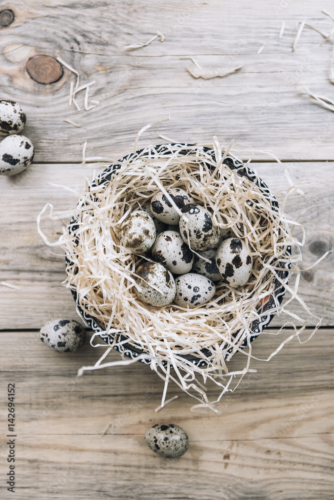 easter quail eggs in the nest on the old rustic wooden table background, flat lay easter quail eggs in the nest on the old rustic wooden table background, flat lay