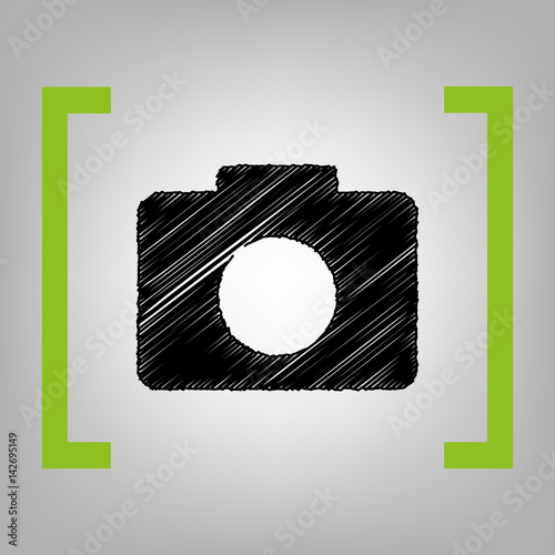 Digital camera sign. Vector. Black scribble icon in citron brackets on grayish background.