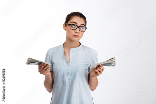 Konstfotografi Young confident beautiful business girl in glasses holding money dreamy looking
