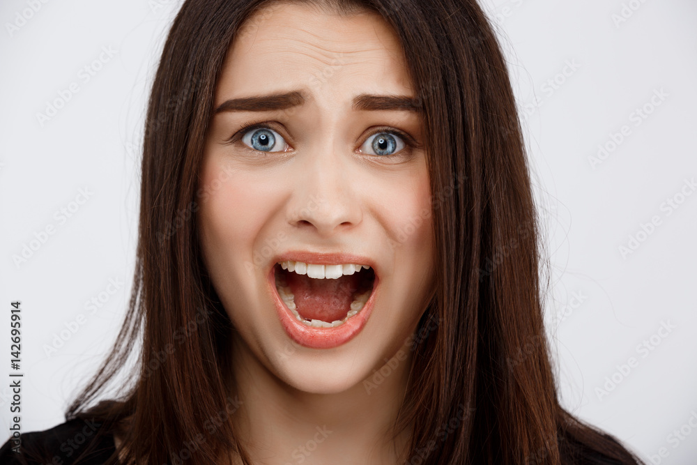 Close up portrait of beautiful scared brunette girl shouting in camera Close up portrait of beautiful scared brunette girl shouting in camera