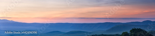 Panoramic view of huge Ngorongoro caldera (extinct volcano crater) against evening glow background at dusk. Great Rift Valley, Tanzania, East Africa. 