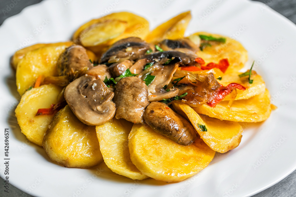 Fried potato with mushrooms and herbs. white plate. selective focus Fried potato with mushrooms and herbs. white plate. selective focus
