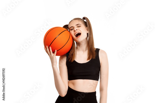 Young pretty girl posing with basketball, isolated on white background. © Cookie Studio