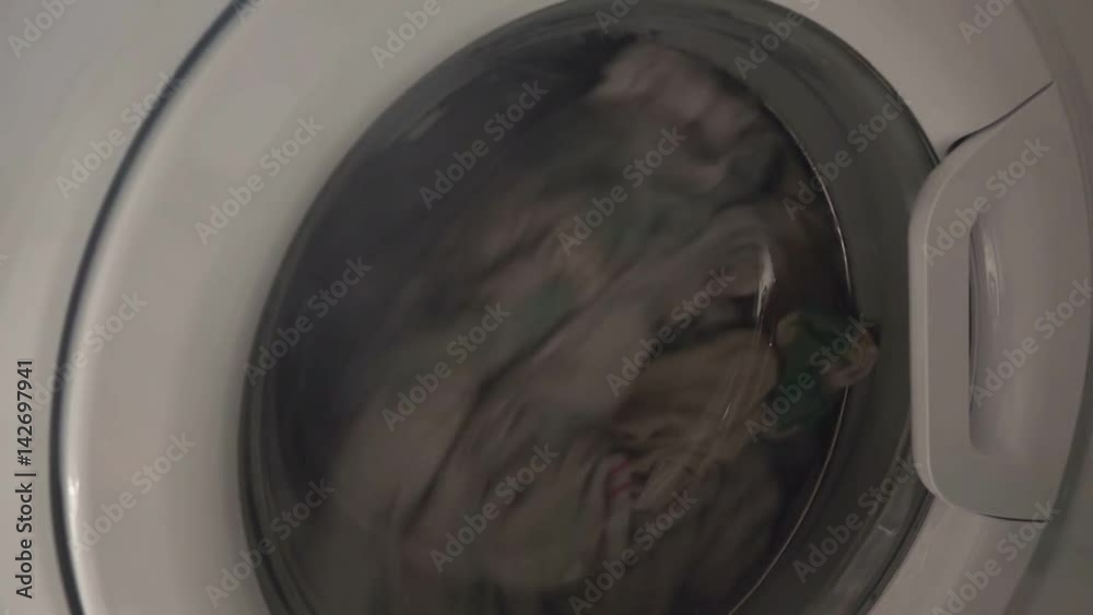 Doing laundry in washing machine, close up of clothes washer front cover Doing laundry in washing machine, close up of clothes washer front cover