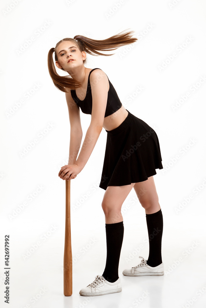 Young pretty girl posing with bat over white background. Young pretty girl posing with bat over white background.