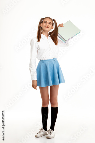 Young emotional pretty girl in uniform posing over white background. © Cookie Studio