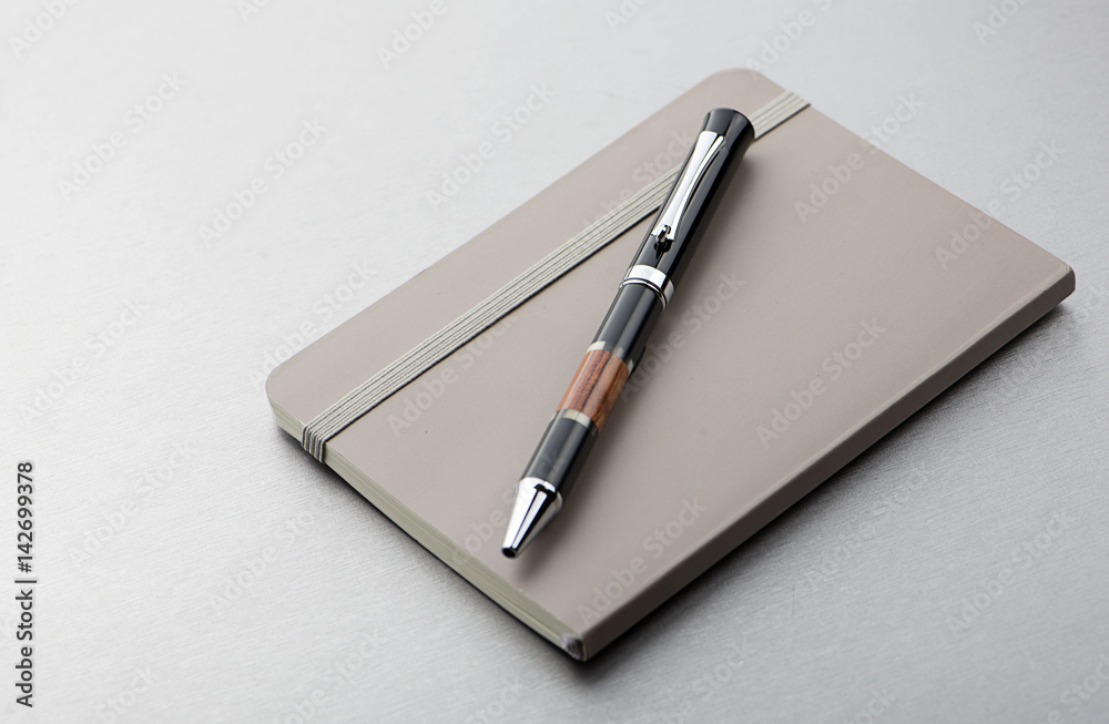 Pen and notepad on gray background. Business and education. Pen and notepad on gray background. Business and education.