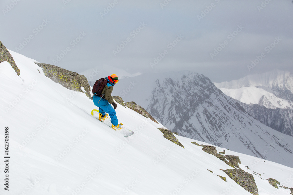 snowboarder snowboarding on fresh snow on ski slope on Sunny winter day in the ski resort in Georgia