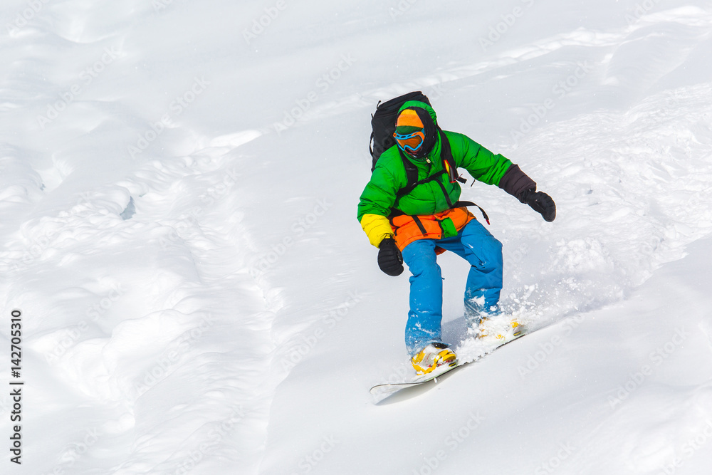 snowboarder snowboarding on fresh snow on ski slope on Sunny winter day in the ski resort in Georgia