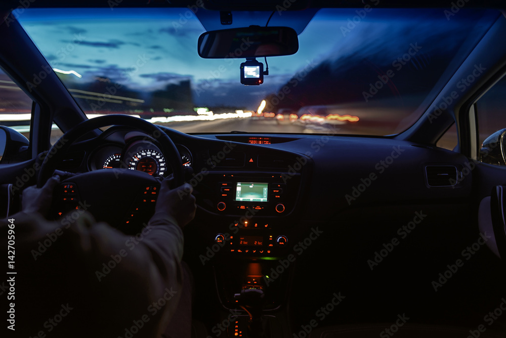 Night road view from inside car natural light street and other cars is motion blurred