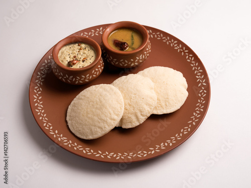 idli with sambar and coconut chutney served in a plate on white background
