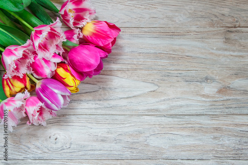 Beautiful floral background. Bouquet of beautiful tulips on a wooden background.