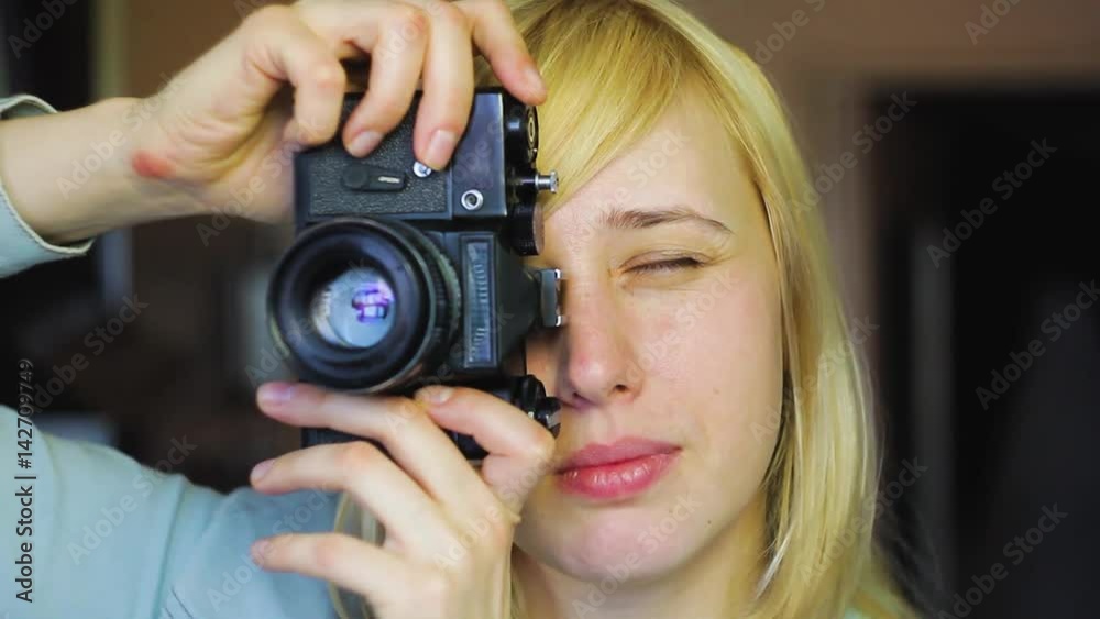 Blonde with different eyes shoots on an old retro camera, heterochromia Blonde with different eyes shoots on an old retro camera, heterochromia