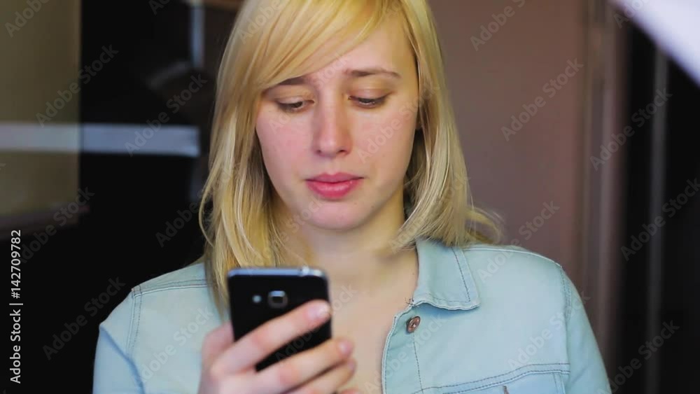 Woman with different eyes working with smartphone and smile, Heterochromia