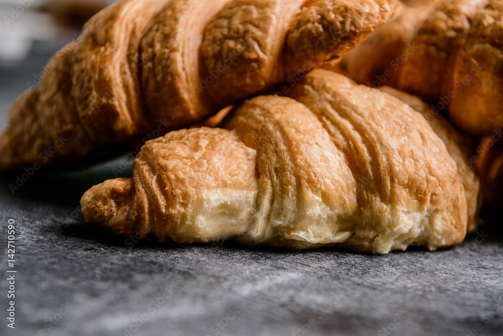 Macro picture of croissants on grey table. 