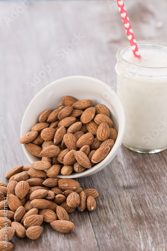 Almonds Spilling From White Bowl With Almond Milk