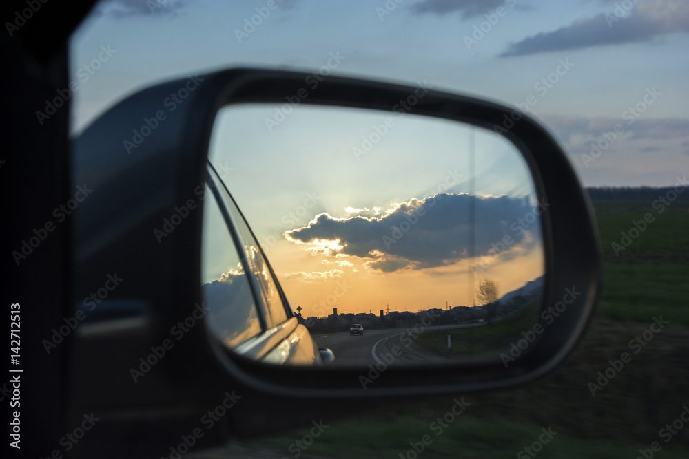 Car rearview mirror with reflection of sunset