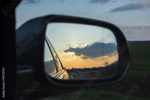 Car rearview mirror with reflection of sunset