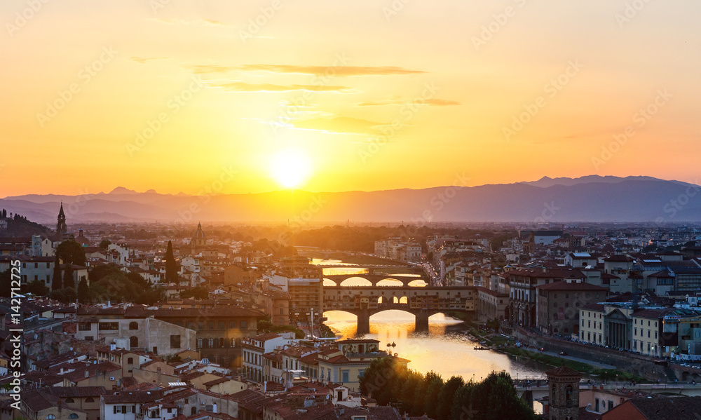 Florence (Firenze). Aerial view of medieval stone bridge Ponte Vecchio and the Arno River in Florence, Tuscany, Italy. Florence is a popular tourist destination of Europe. Colorful summer sunset.