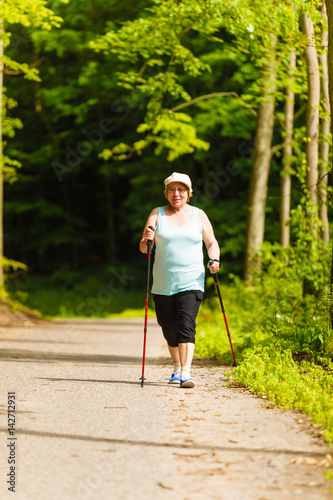 Senior woman practicing nordic walking in park
