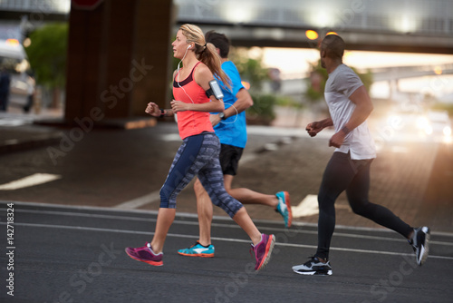 Multi-ethnic fit active friends running together in the city
