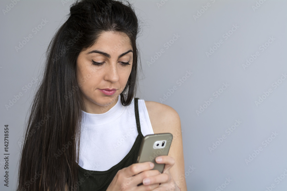 Portrait of young sad annoyed woman with cellphone in the hand Portrait of young sad annoyed woman with cellphone in the hand