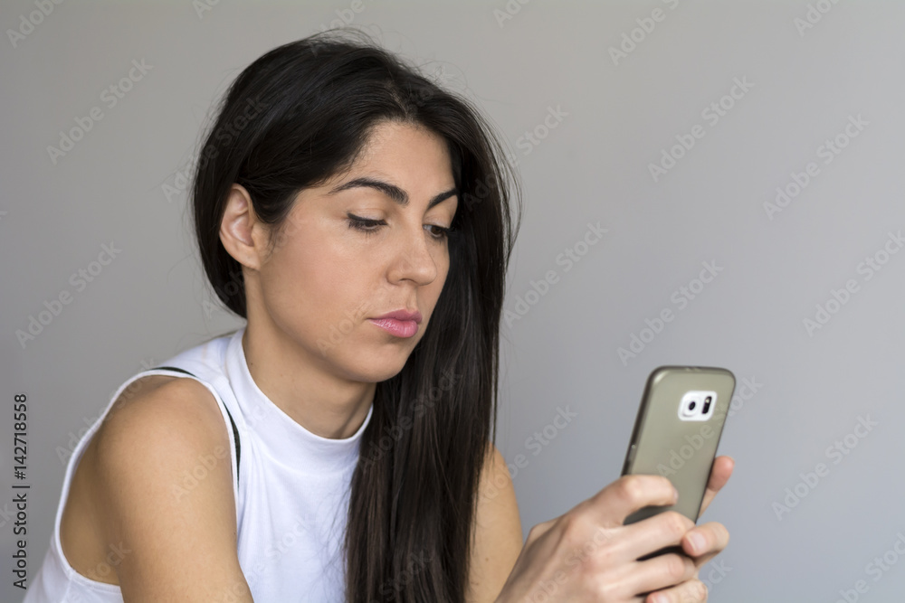 Portrait of young sad annoyed woman with cellphone in the hand Portrait of young sad annoyed woman with cellphone in the hand