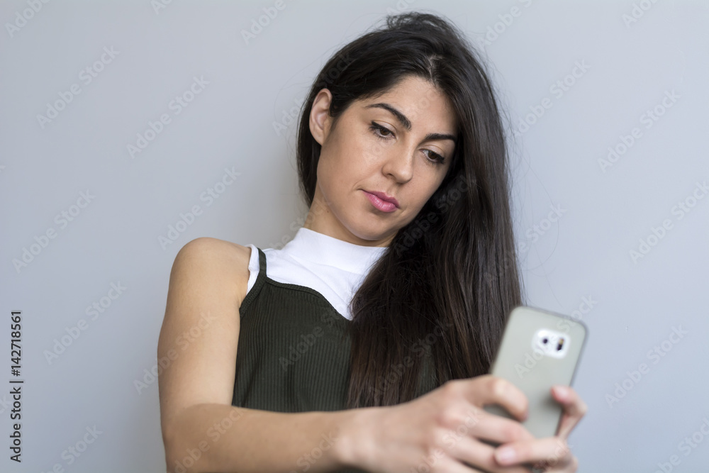 Portrait of young sad annoyed woman with cellphone in the hand Portrait of young sad annoyed woman with cellphone in the hand