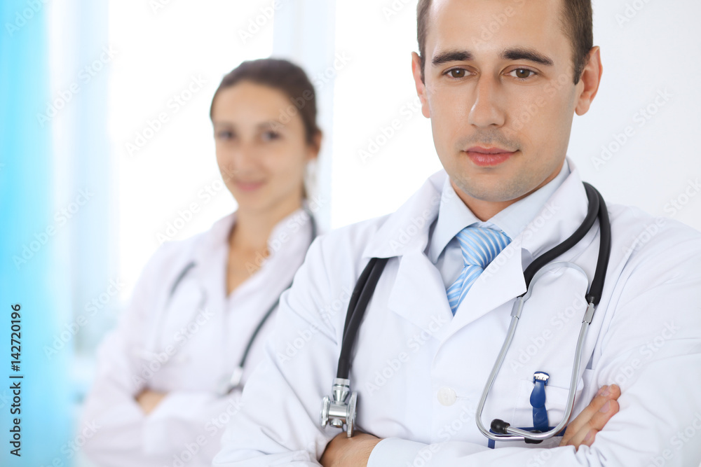 Cheerful smiling male doctor with medical staff at the hospital Cheerful smiling male doctor with medical staff at the hospital