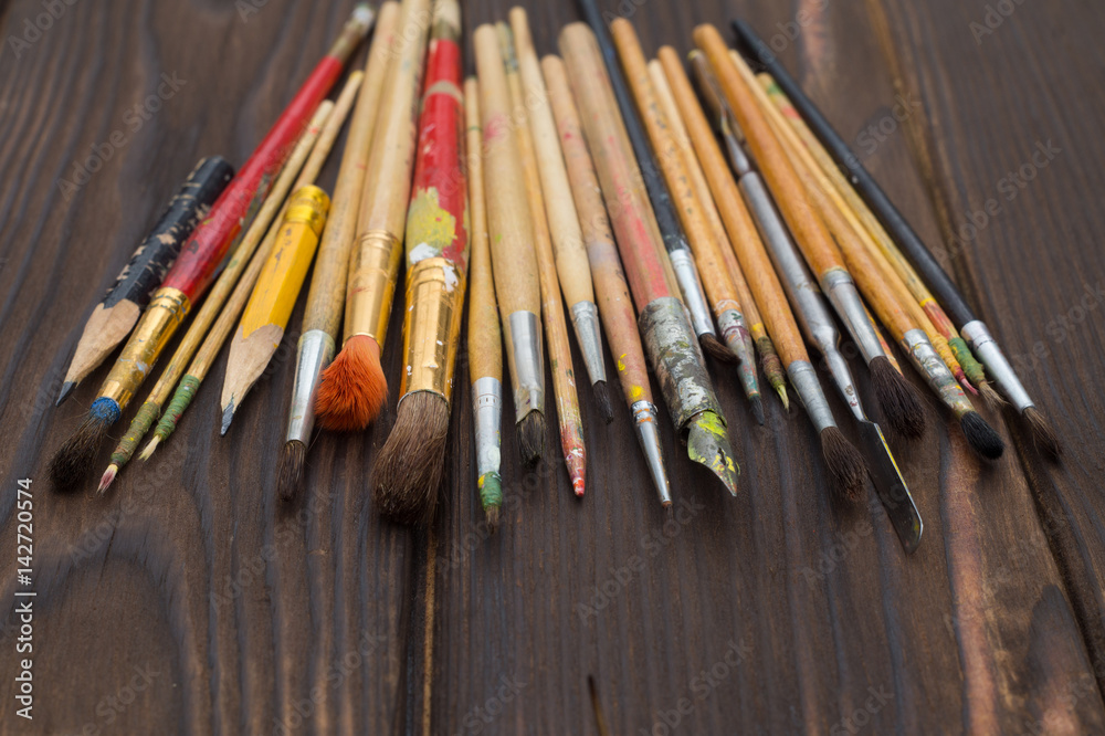 Brushes spread out on a dark wooden surface