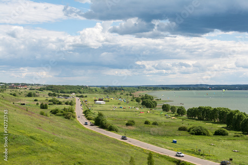 Romantic road into the distance, horizon, lake and green flat plain. Sports and recreation in auto kemping on Plesheevo lake resort.