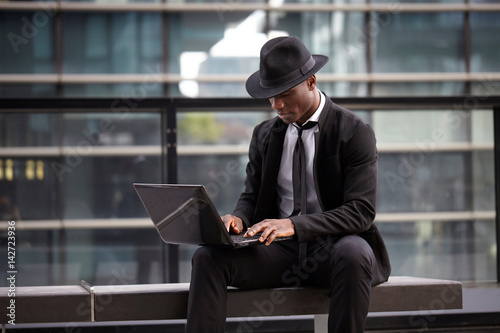 businessman working on laptop computer outdoors