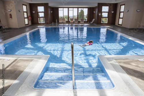 Little girl enjoying swimming pool indoors