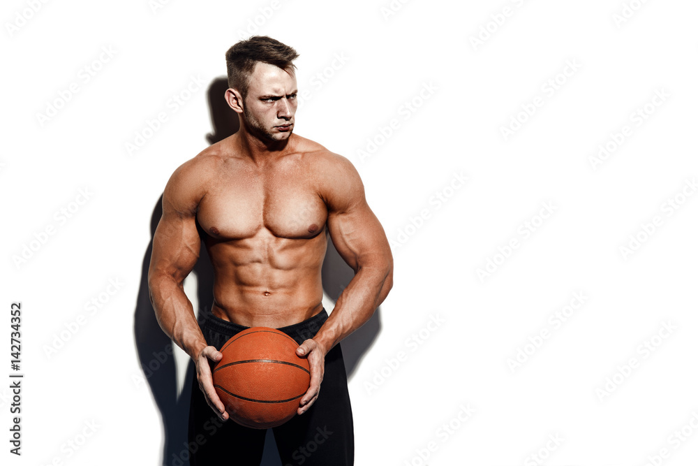 Very muscular naked man holding a basketball in studio Stock Photo | Adobe  Stock
